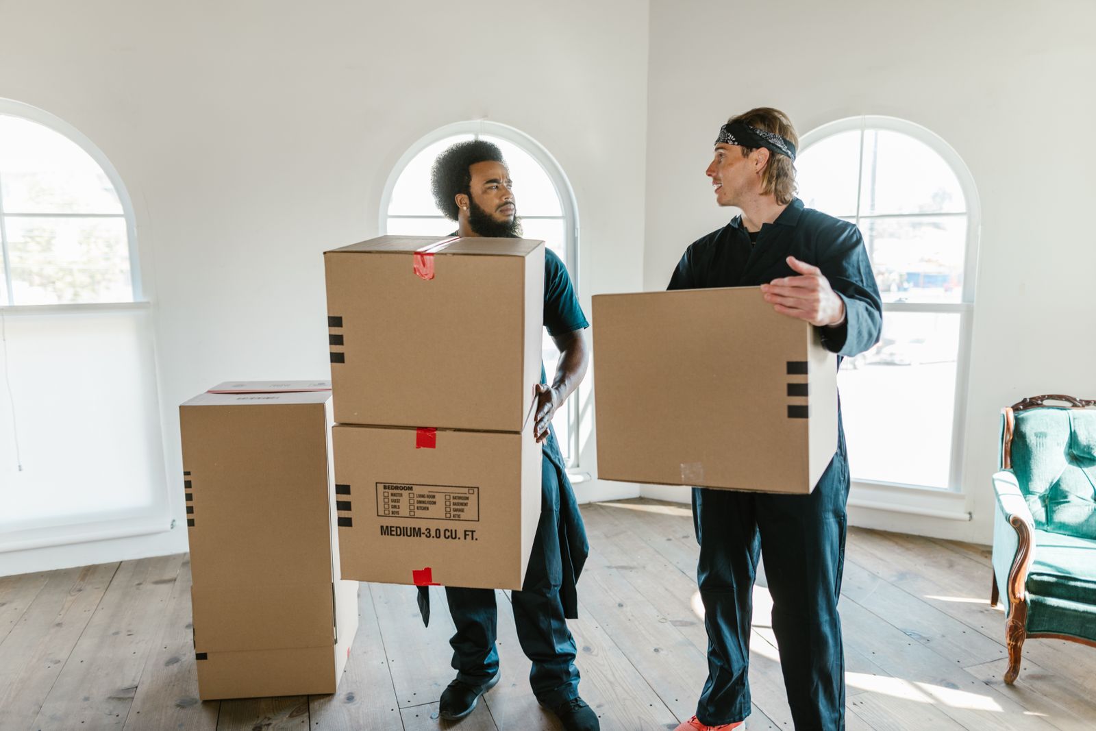 Two Nyati Movers crew members carrying boxes during a house move